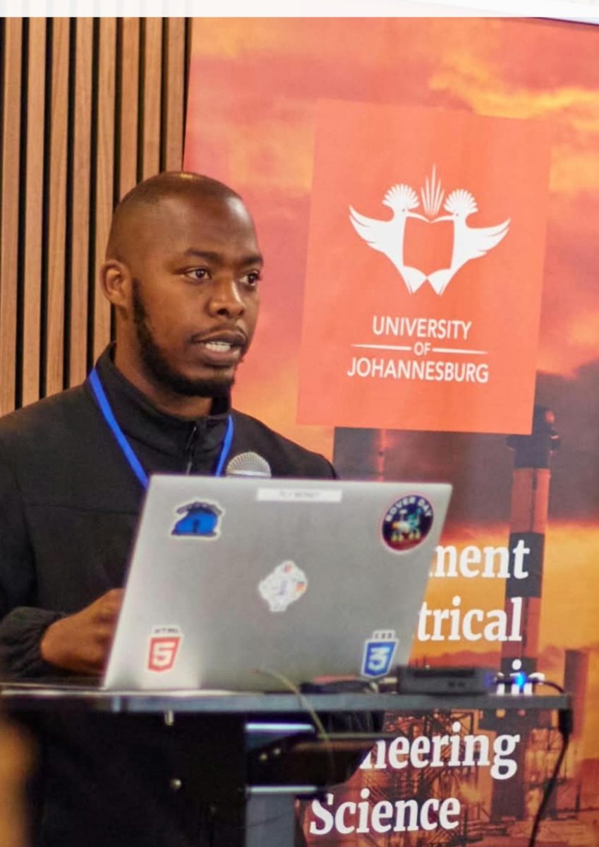 Prosper presenting at a lectern in front of a University of Johannesburg banner